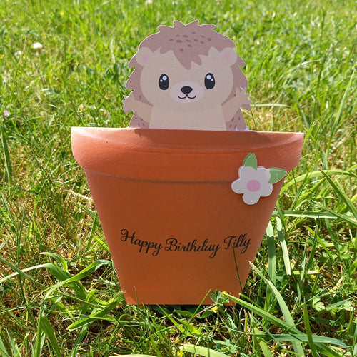 A flowerpot card with a cute hedgehog peeking out of it