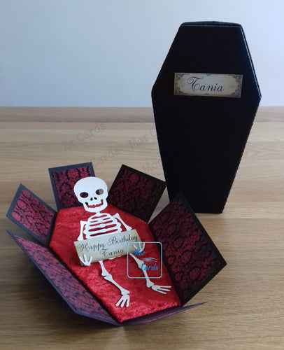 An exploding box card coffin with skeleton inside holding a personalised panel